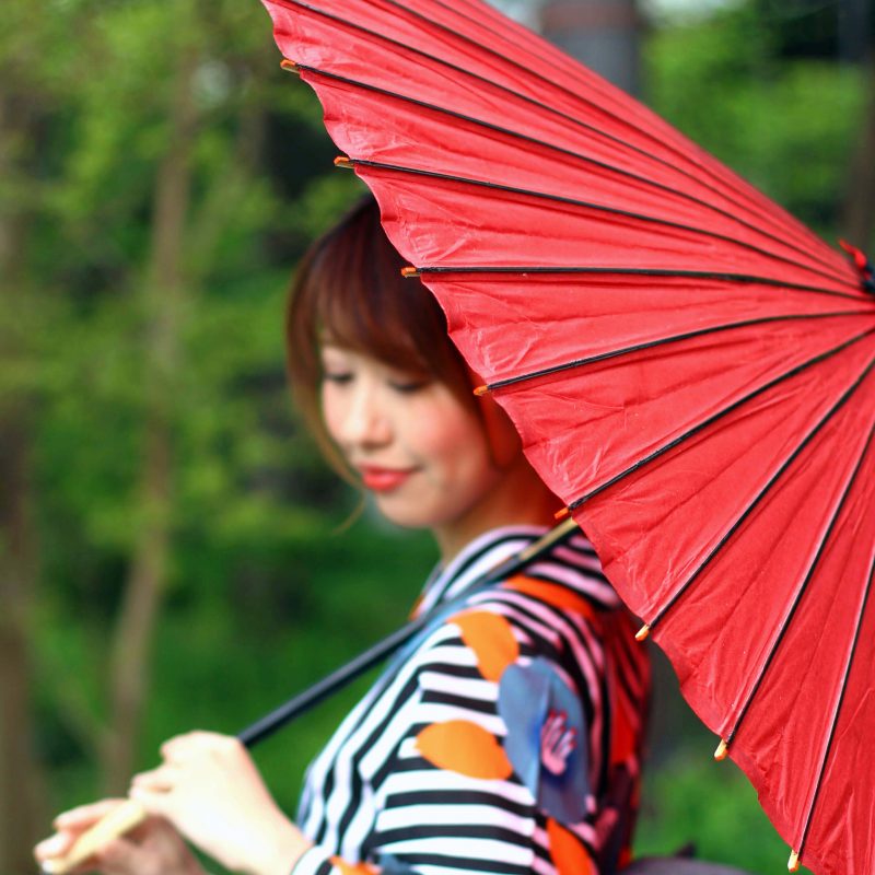 赤色の和傘をさす女性