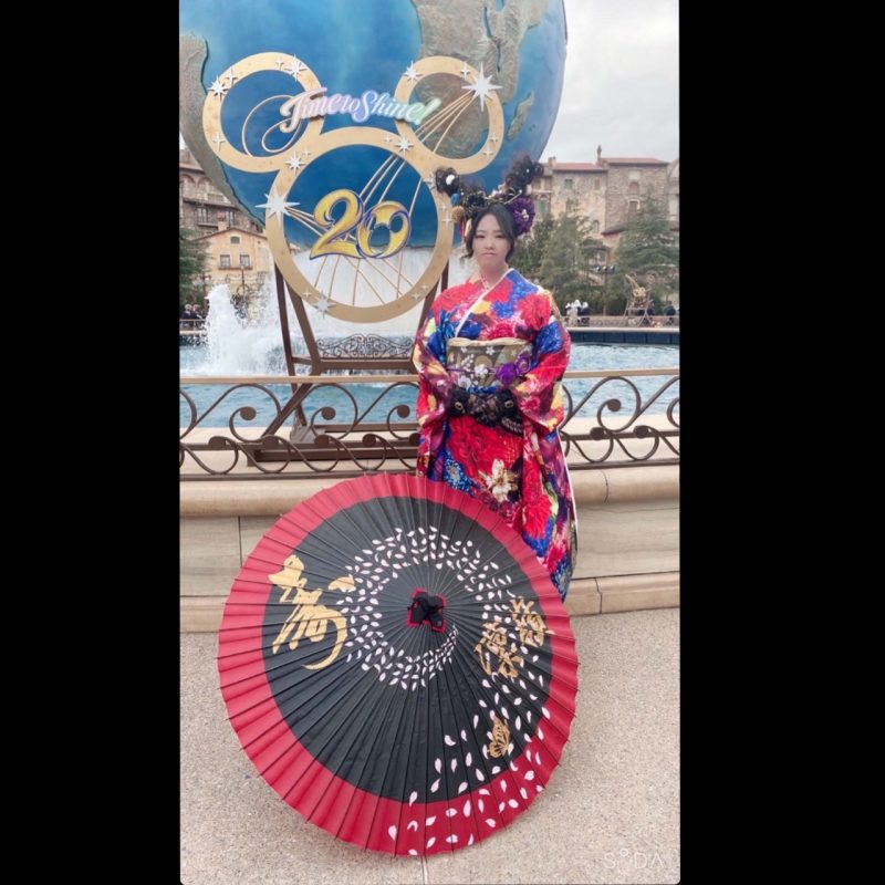 成人式の日に着物姿でで和傘を前にして立つ女性