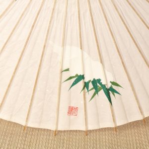手描きの笹に雪が積もった絵が描かれた白い和日傘