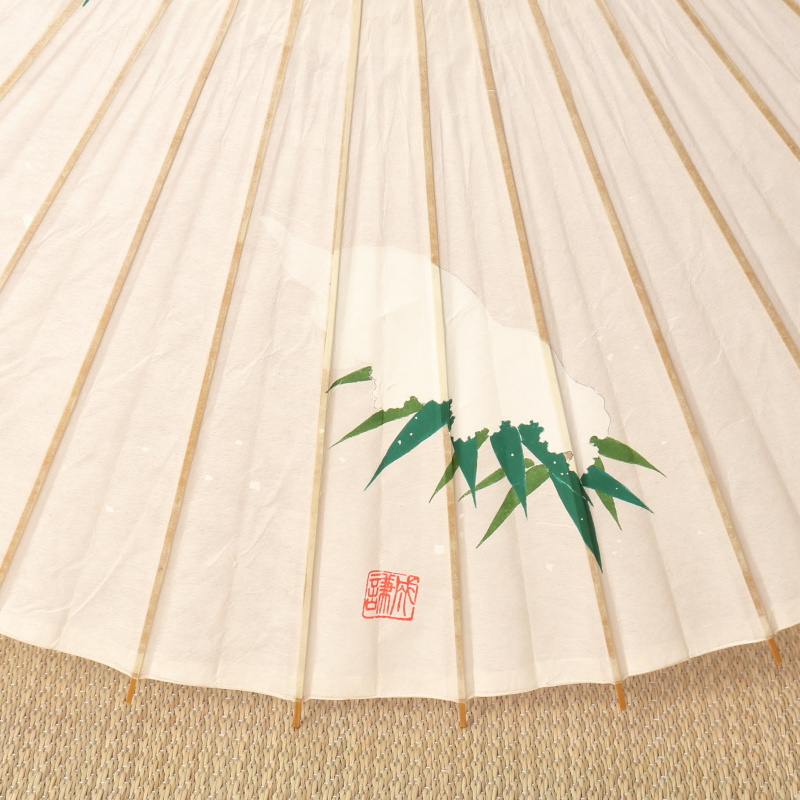 手描きの笹に雪が積もった絵が描かれた白い和日傘